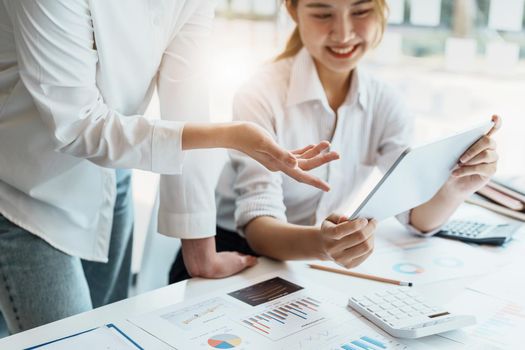 Negotiation, Analysis, Discussion, Portrait of an Asian women economist and marketer using tablet computer to plan investments and financial to prevent risks and losses for the company.