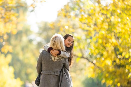 happy family: mother and child little daughter play on autumn walk in nature outdoors.