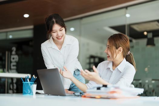 Negotiation, Analysis, Discussion: Portrait of an Asian female economist and marketer using computer laptop to plan investments and financial to prevent risks and losses for the company.