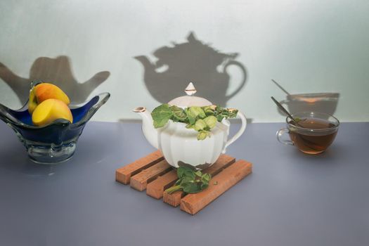 On the table in a teapot and a Cup of healthy herbal tea with sage.