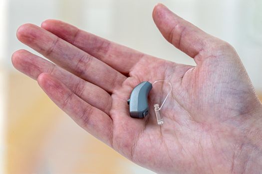 Hearing aid in close-up in the palm of your hand