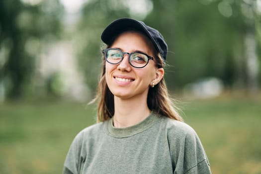 Portrait of a smiling young girl with glasses in the park. High-quality photo