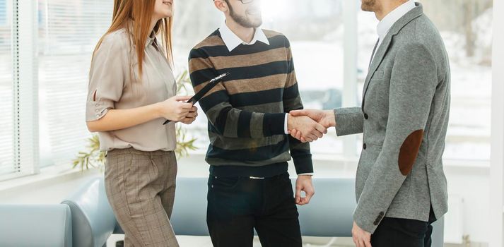 senior Manager shakes hands with the employee in a workplace in a modern office