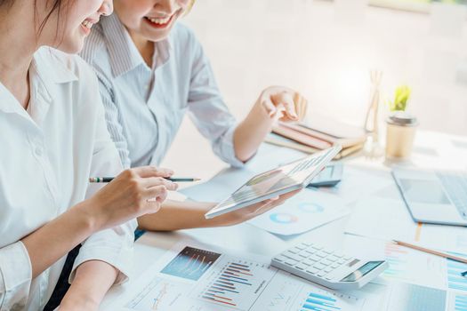 Negotiation, Analysis, Discussion, Portrait of an Asian women economist and marketer using tablet computer to plan investments and financial to prevent risks and losses for the company.