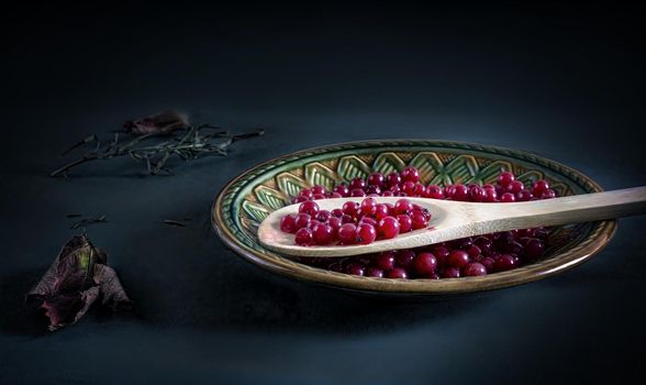 On the table in a ceramic plate juicy red currant berries