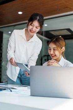 Negotiation, Analysis, Discussion, Portrait of an Asian woman economist and marketer using tablet computer to plan investments and financial to prevent risks and losses for the company.