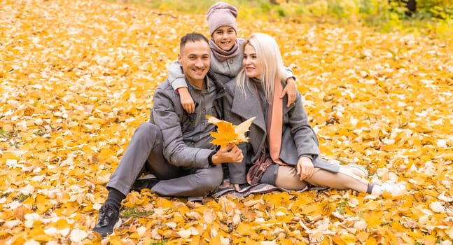 The family walks in the autumn forest and enjoys the autumn colors.
