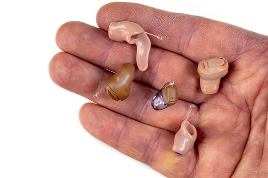 In-ear prosthesis on a finger, surrounded by other models.