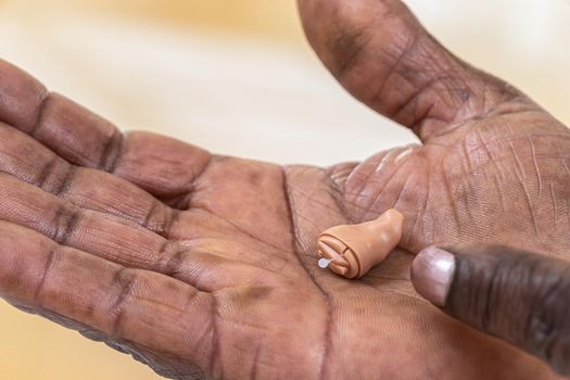 Hearing aid in close-up in the palm of your hand