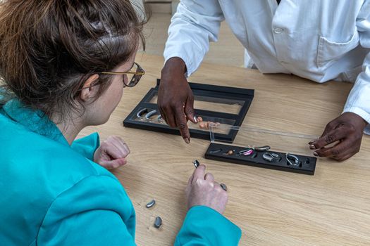 Patient trying different types of hearing aids. dialoguing with his hearing aid worker