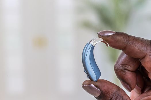 Prosthesis in close-up between two fingers on a light background