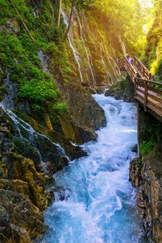 Beautiful Wimbachklamm gorge with wooden path in autumn colors, Ramsau bei Berchtesgaden in Germany. Waterfall at Wimbachklamm near Ramsau-Berchtesgaden, Bavaria, Germany.