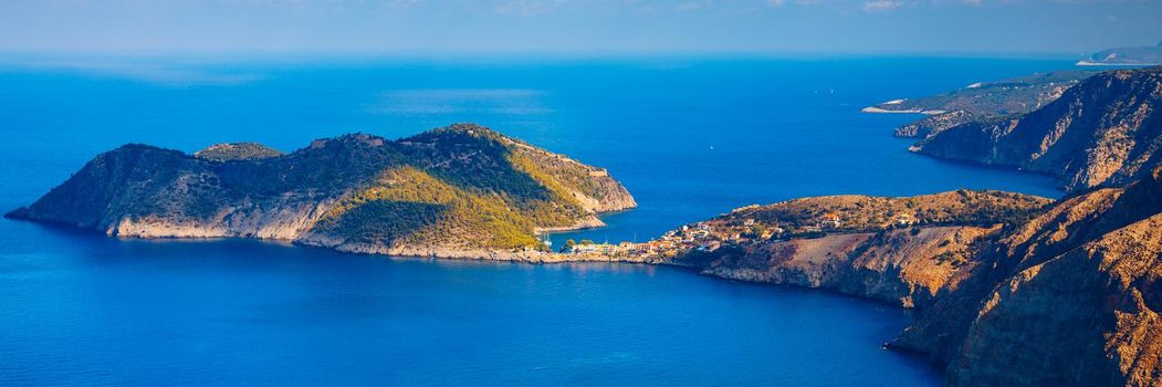 Assos village in Kefalonia, Greece. Turquoise colored bay in Mediterranean sea with beautiful colorful houses in Assos village in Kefalonia, Greece, Ionian island, Cephalonia, Assos village.