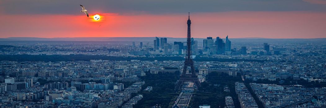 View of Paris with Eiffel Tower from Montparnasse building. Eiffel tower view from Montparnasse at sunset, view of the Eiffel Tower and La Defense district in Paris, France.