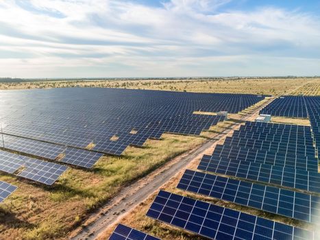 Aerial top view of a solar panels power plant. Photovoltaic solar panels at sunrise and sunset in countryside from above. Modern technology, climate care, earth saving, renewable energy concept