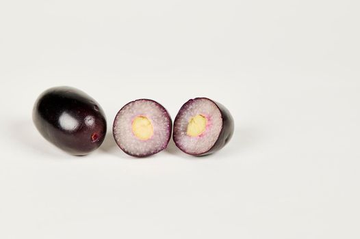 Whole and cut Jambolan plum or Java Plum or Jamun fruit on a white background