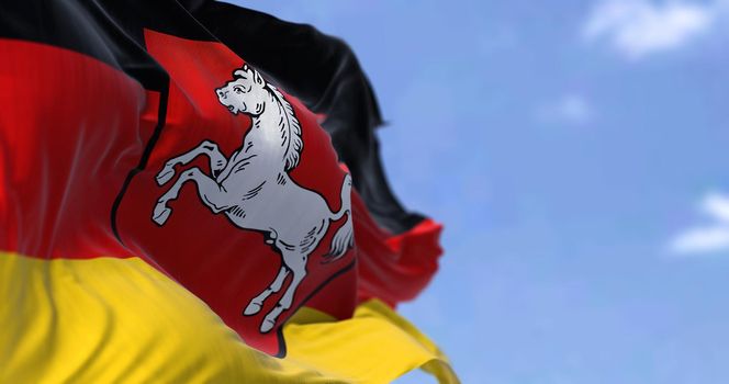 The flag of Lower Saxony waving in the wind on a clear day. Lower Saxony is a German state (Land) situated in northwestern Germany