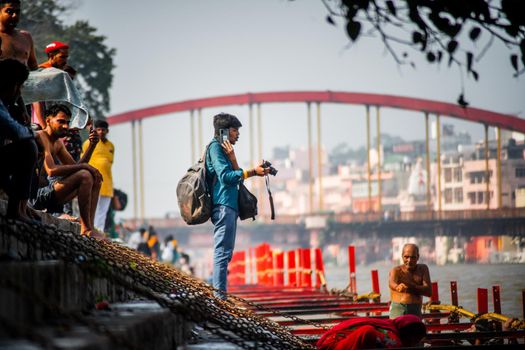 Haridwar, Uttarakhand, India - circa 2021 : Professional small time photographer standing on the banks of the ganga ghat taking pictures of visitors, this is a common side business for photographers in tourist destinations like haridwar