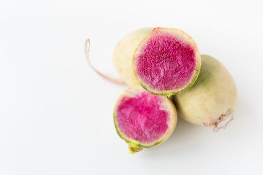 Delicious pink radish in the cut of the dragon's eye variety on a white background. View from above