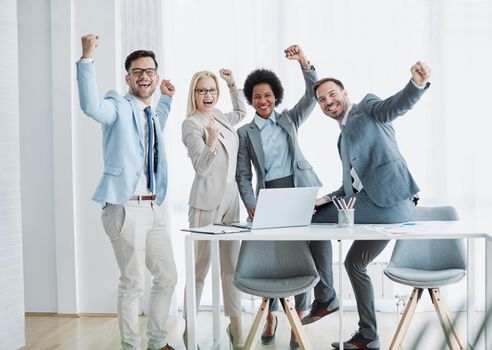 Group of young business peoplecelebrating during a meeting in the office. Teamwork and success concept