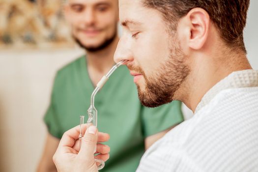 Man receives nasal inhalation Maholda by essential oil in nose at spa.