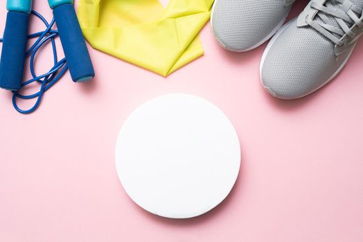 Exercise equipment on a pink background with a round mock up. Copy space, flat lay. The concept of doing sports. Healthy lifestyle.