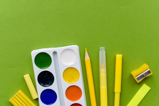 Back to school. Items for the school on a green table.