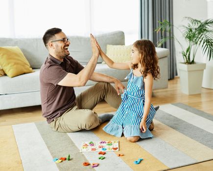 Family having fun playing board games in living room at home