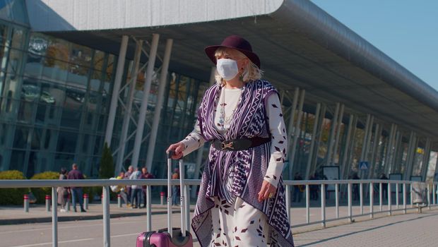 Portrait one unhappy old senior woman grandmother businesswoman wearing Protective Face Mask COVID-19 coronavirus infection near airport pandemic disease virus tourist, epidemic illness, slow motion.