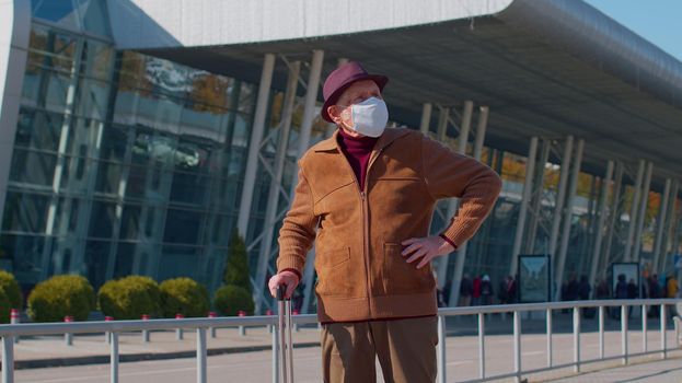 One unhappy old senior man grandfather businessman wearing Protective Face Mask COVID-19 coronavirus infection near airport pandemic disease virus male tourist epidemic illness, sickness