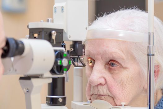 A male ophthalmologist checks the eyesight of an adult woman using a modern device with a light beam. Moscow Russia May 27, 2022.
