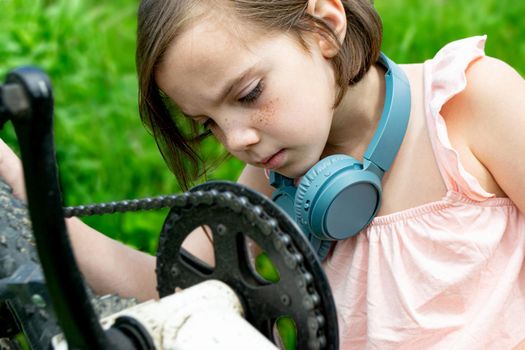 a child girl has damaged a bicycle wheel and is making repairs photo without processing. High quality photo