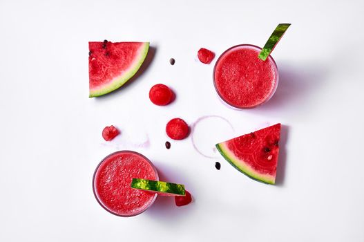 Fresh watermelon juice or smoothie in glasses with watermelon pieces on white background. Refreshing summer drink. Creative minimal concept. Top view Flat lay.
