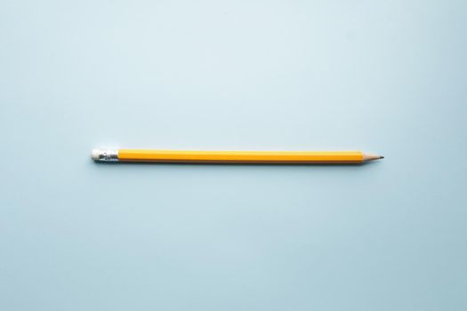 Yellow pencil on blue background, learning creative concept