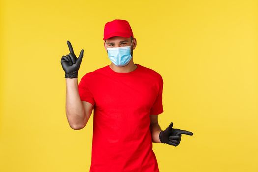 Express delivery during pandemic, covid-19, safe shipping, online shopping concept. Smiling cute courier in medical mask provide options for contactless package transfer, pointing left and right.