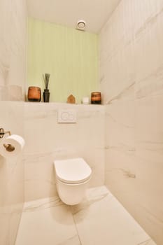 Interior of narrow restroom with sink and wall hung toilet with white walls and checkered floor