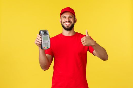 Contactless payment, online delivery, internet shopping and parcel tracking concept. Pleased handsome bearded courier, male employee show thumb-up, recommend POS terminal paying.
