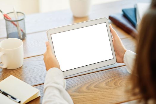 Close up of woman's hands holding a tablet in an office or at home