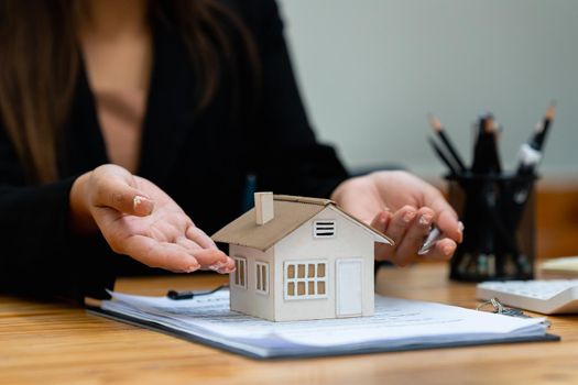 A woman holding and checking house model .Real Estate House Appraisal And Inspection and Insurance concept