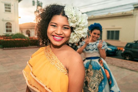 Two traditional dancers with the typical Nicaraguan costume having fun, goofing around and fooling around during sunset on a street in Leon Nicaragua. Dresses are similar to those of Central America