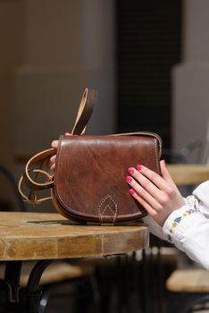 small yellow women's leather bag with rivets. selective focus. outdoors photo