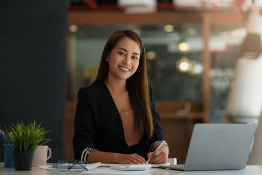 A portrait of Asian happy Businesswoman smiling and working at office