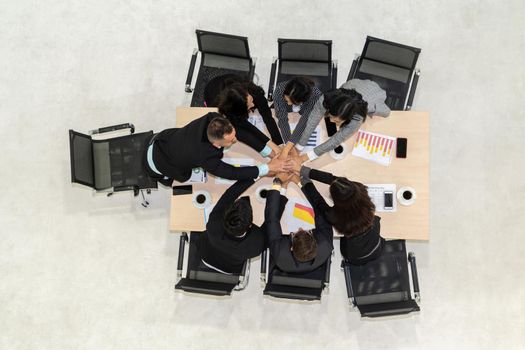 Happy business people celebrate teamwork success together with joy at office table shot from top view . Young businessman and businesswoman workers express cheerful victory showing unity and support .
