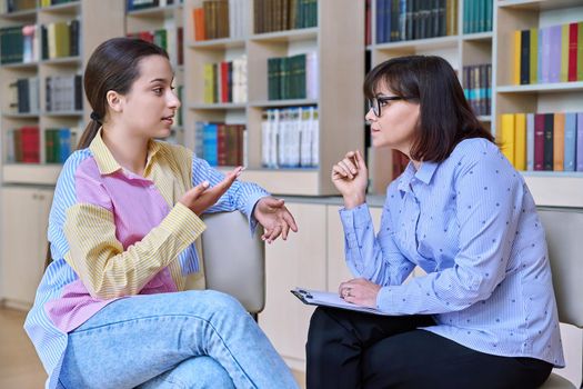 Psychologist, teacher, behavior, high school counselor counseling teenage student in library, office. Psychological help, social work, mental health, adolescence, youth psychotherapy psychology concept