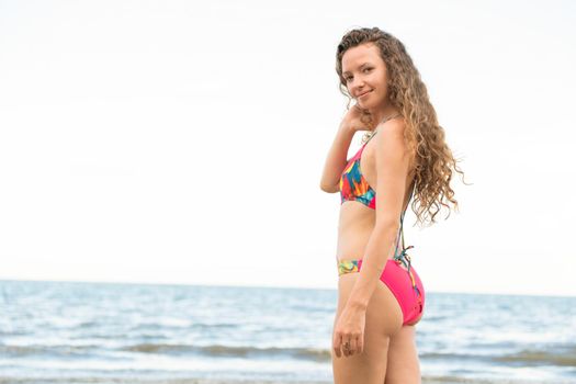 Happy young woman wearing swimsuit having good time at tropical beach in summer for holiday travel vacation.