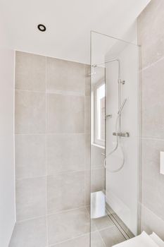 Cozy shower cabinet with glass door and grey tiled walls