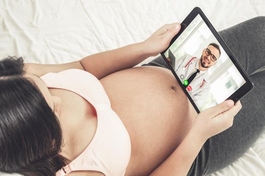 Doctor telemedicine service online video with pregnant woman for prenatal care . Remote doctor healthcare consultant from home using online mobile device connect to internet for live video call .