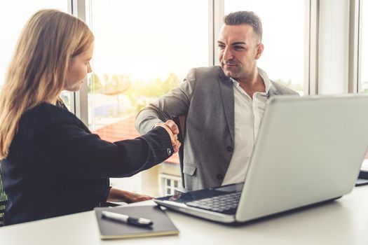 Businessman executive handshake with businesswoman worker in modern workplace office. People corporate business deals concept.