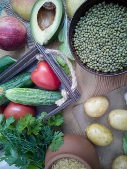 A variety of organic food items on the wooden table: fruits, vegetables, eggs, bulgur cereals, beans with sprouts. The concept of healthy eating. The view from the top