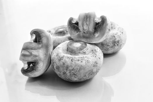 A few fresh raw mushrooms on a light background. Front view, close-up, copy space